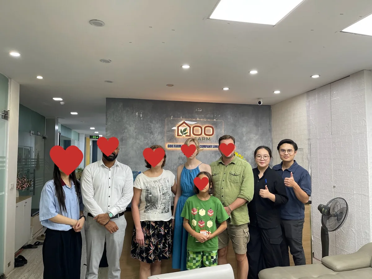 Visiting customers with the Goo Farm team in front of the company sign at the Hanoi office
